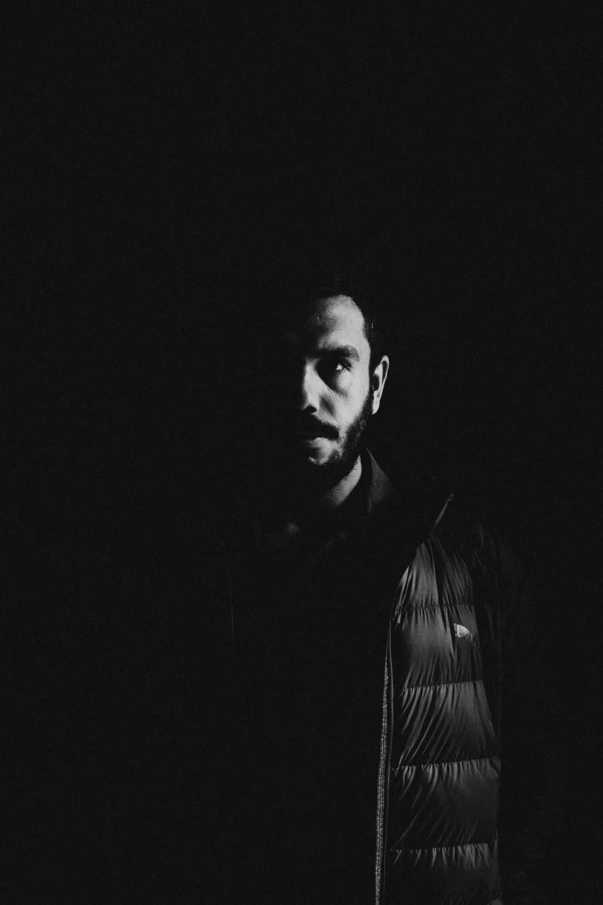 Half-lit profile emerging from black