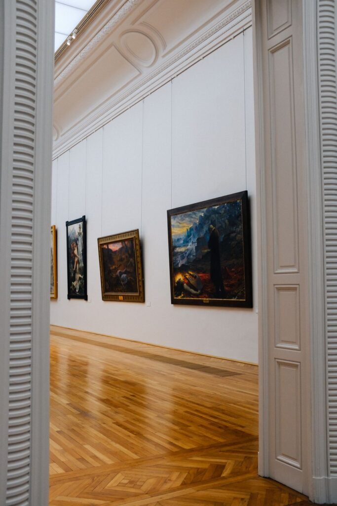 Framed paintings hung along a softly lit gallery wall