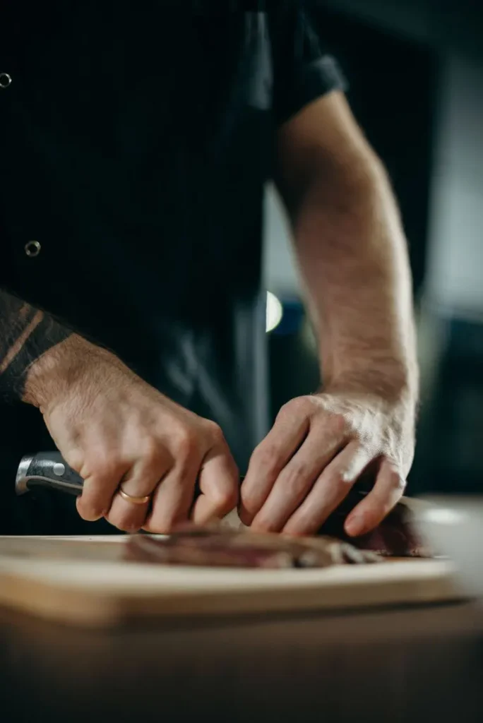 Chef slicing ingredients on a wooden board