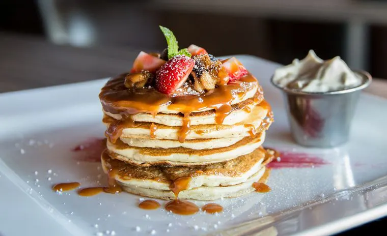 Stack of pancakes with berries and syrup