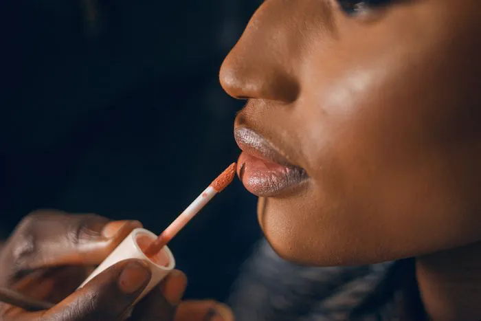 Close-up of glossy lipstick being applied