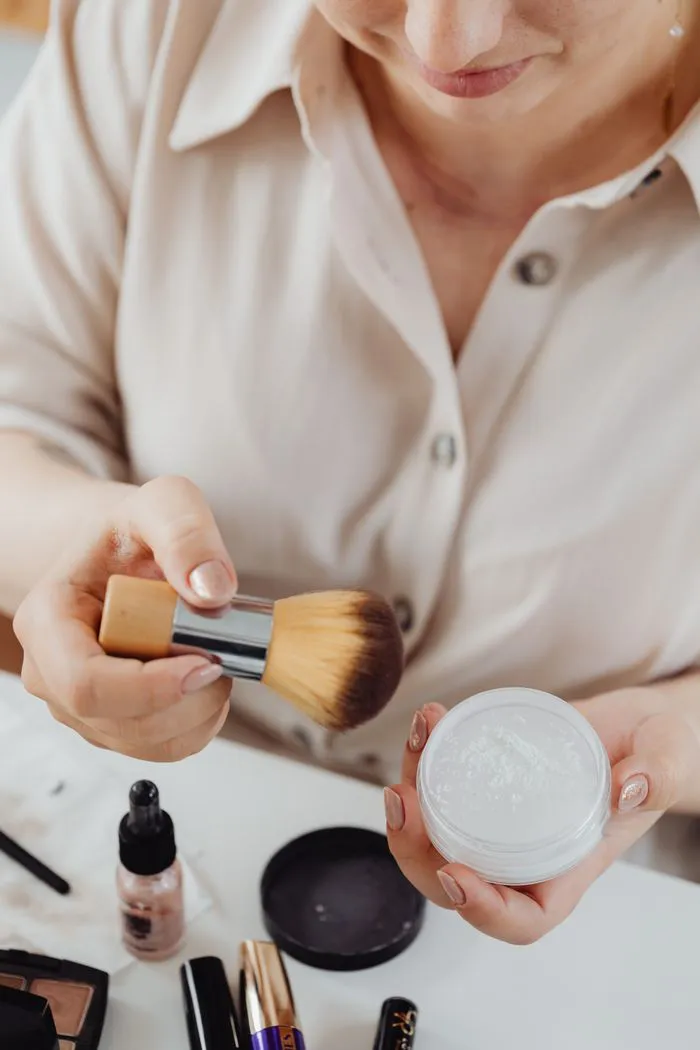 Woman applying loose powder with a makeup brush