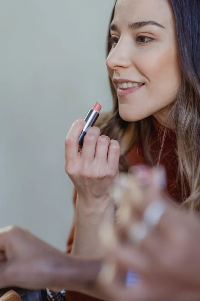 Two smiling friends trying lipstick together