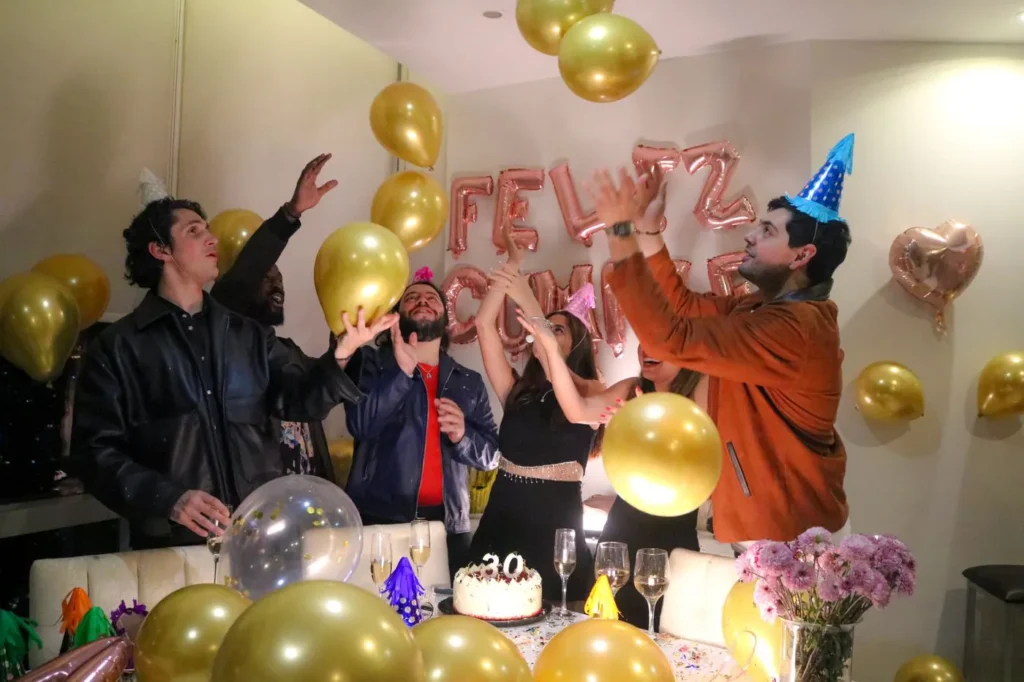 Friends celebrating a birthday among balloons