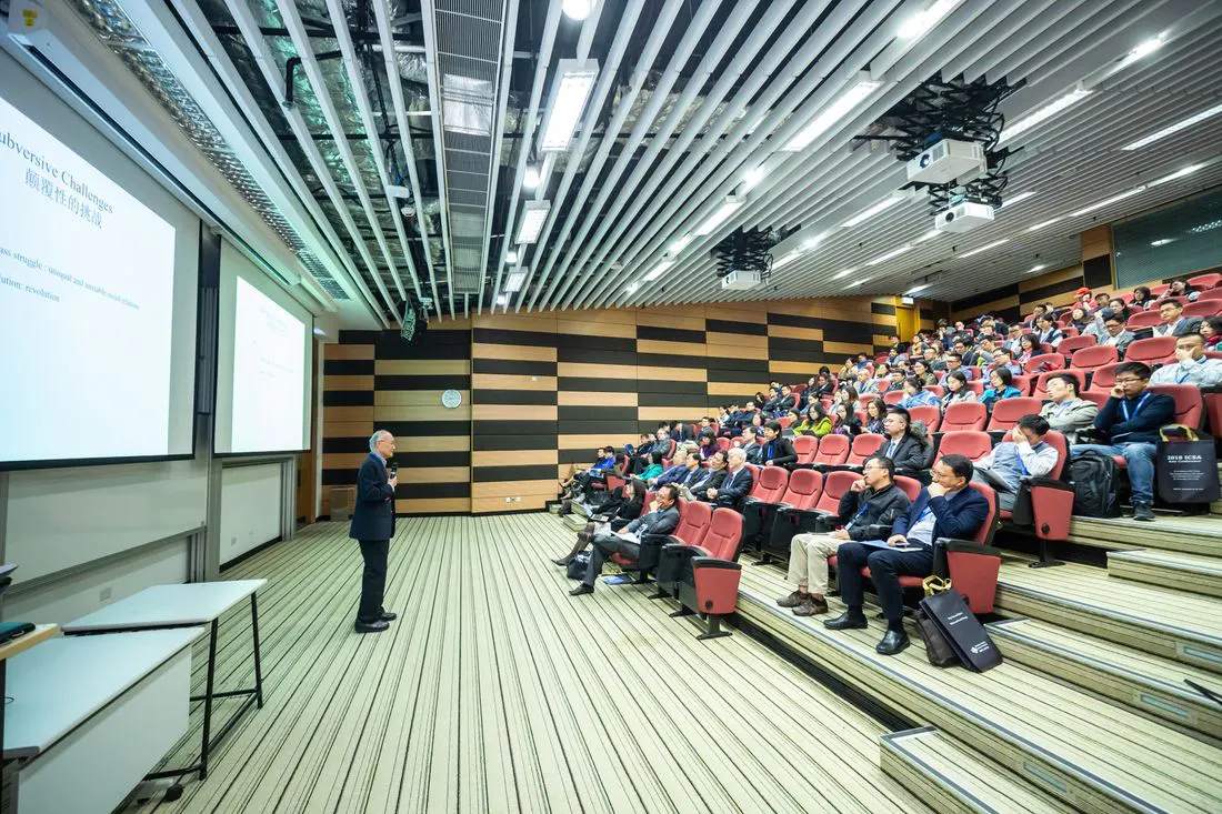 Speaker addressing an audience in a modern auditorium