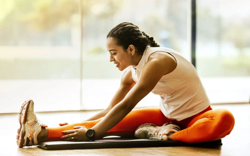 Woman stretching her hamstrings on a mat