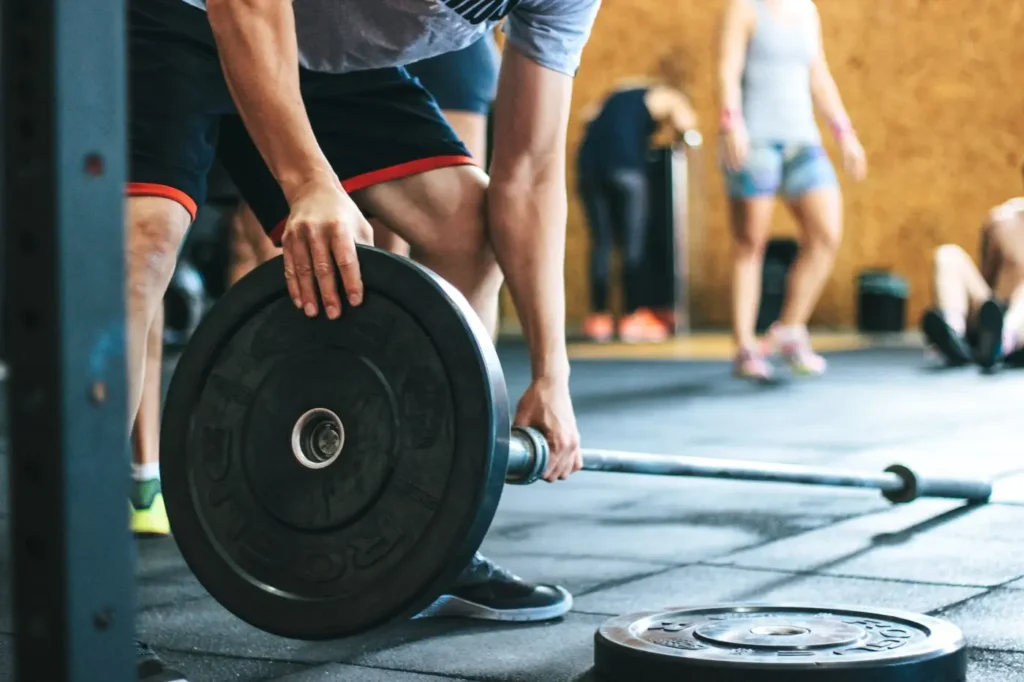 Athlete loading weight plates onto a barbell