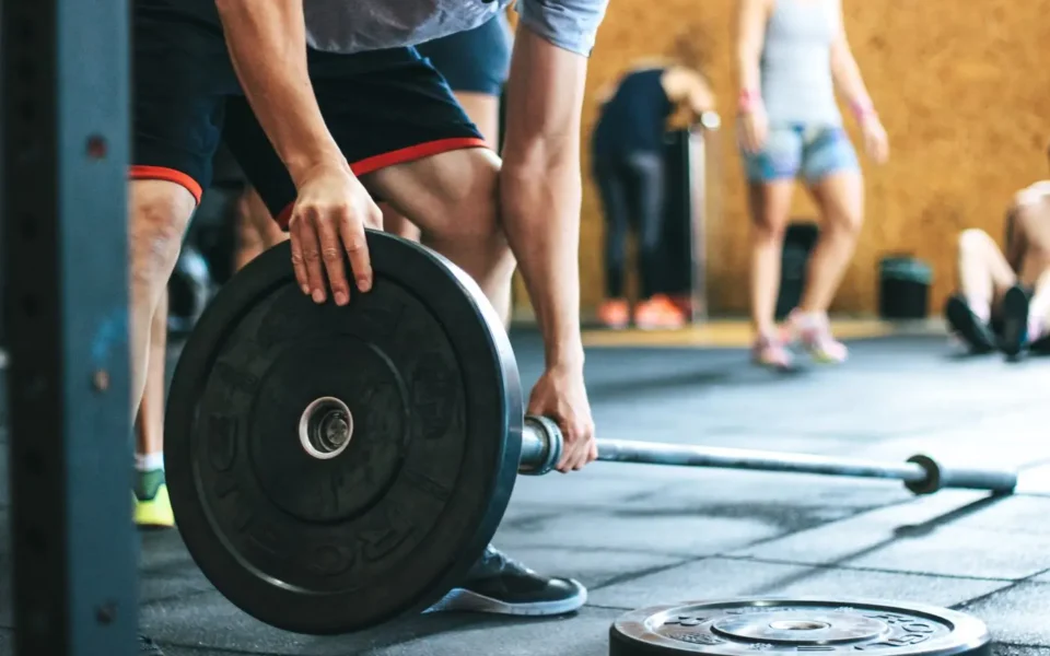 Athlete loading weight plates onto a barbell