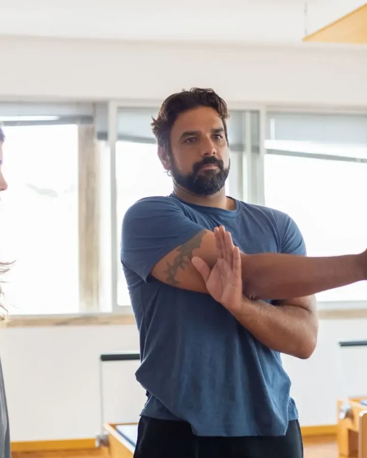 Trainer guiding a stretching session in the gym