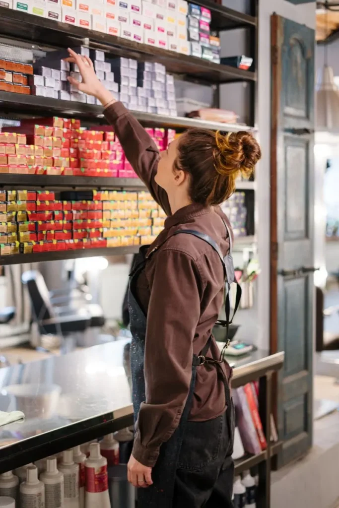 Stylist choosing hair colour from salon shelves