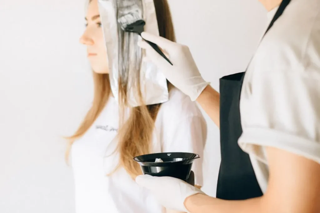 Hairdresser painting balayage with foils