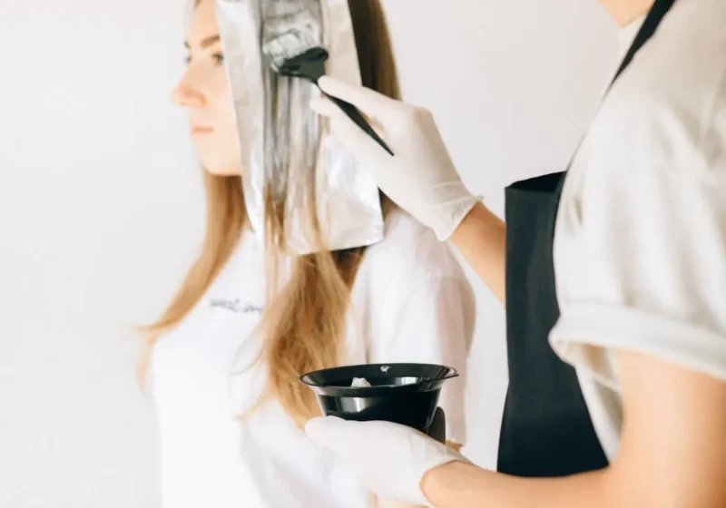 Hairdresser applying colour with foils