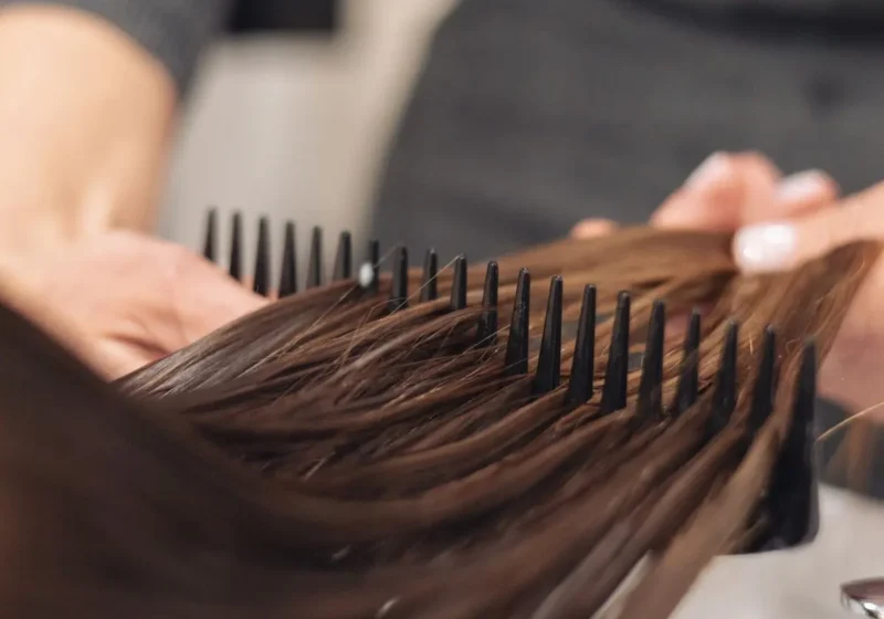 Stylist combing wet hair after treatment
