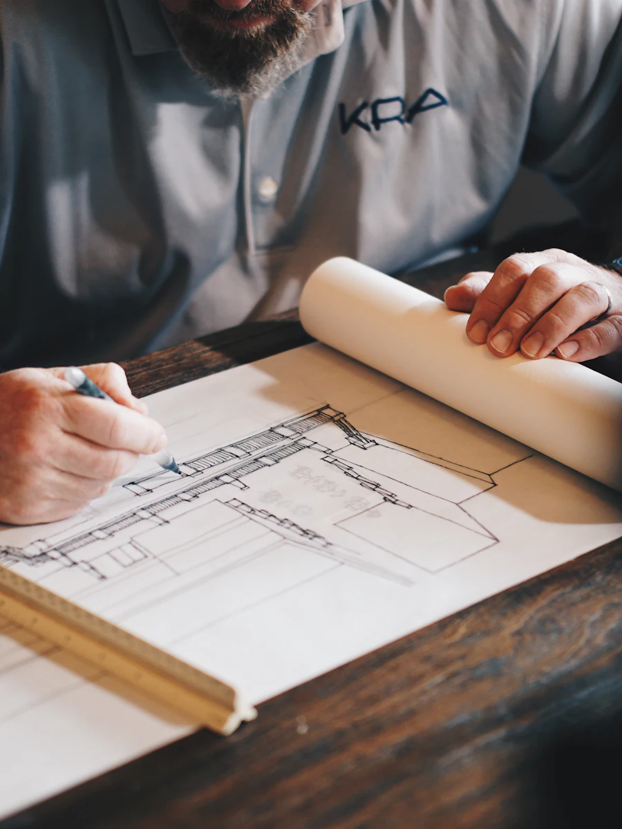 Builder marking measurements on a set of house drawings