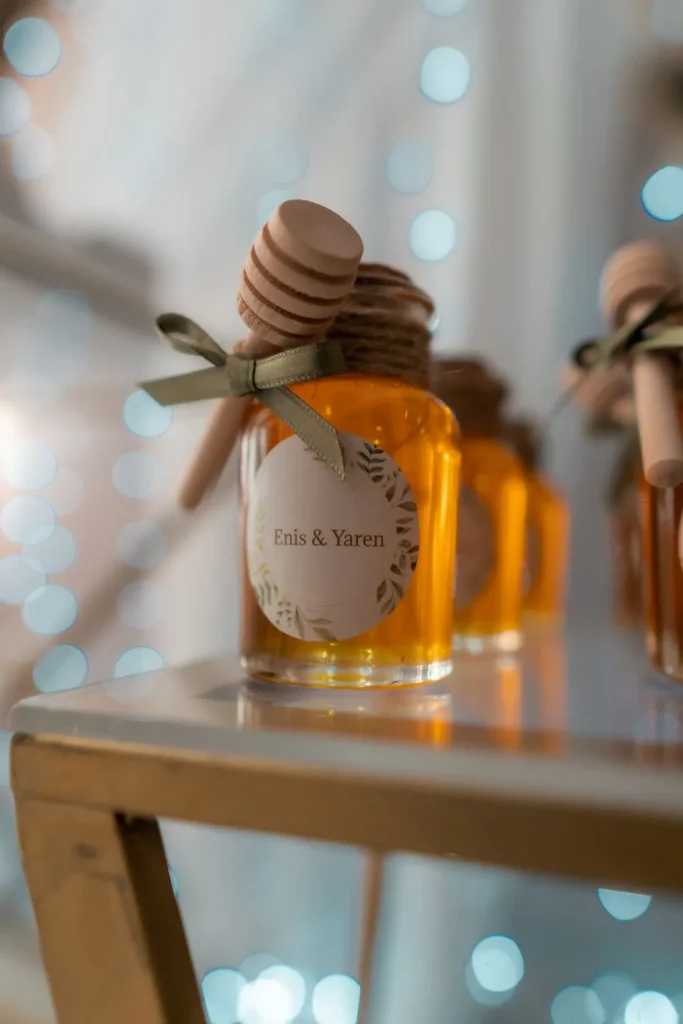Honey jar tied with a ribbon and wooden dipper against warm lights