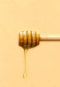 Honey drizzling on a yellow background