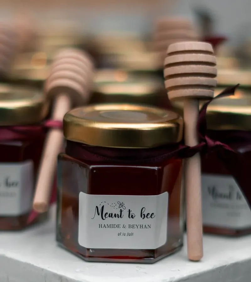 Honey jars tied with ribbons and dippers