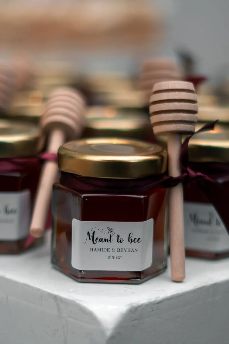 Honey jars tied with ribbons and dippers