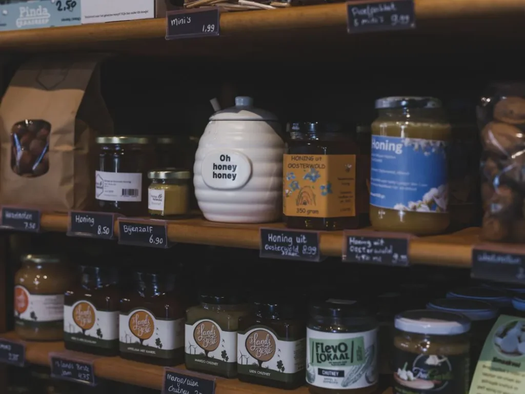 Artisan honey jars on wooden shelves in a shop