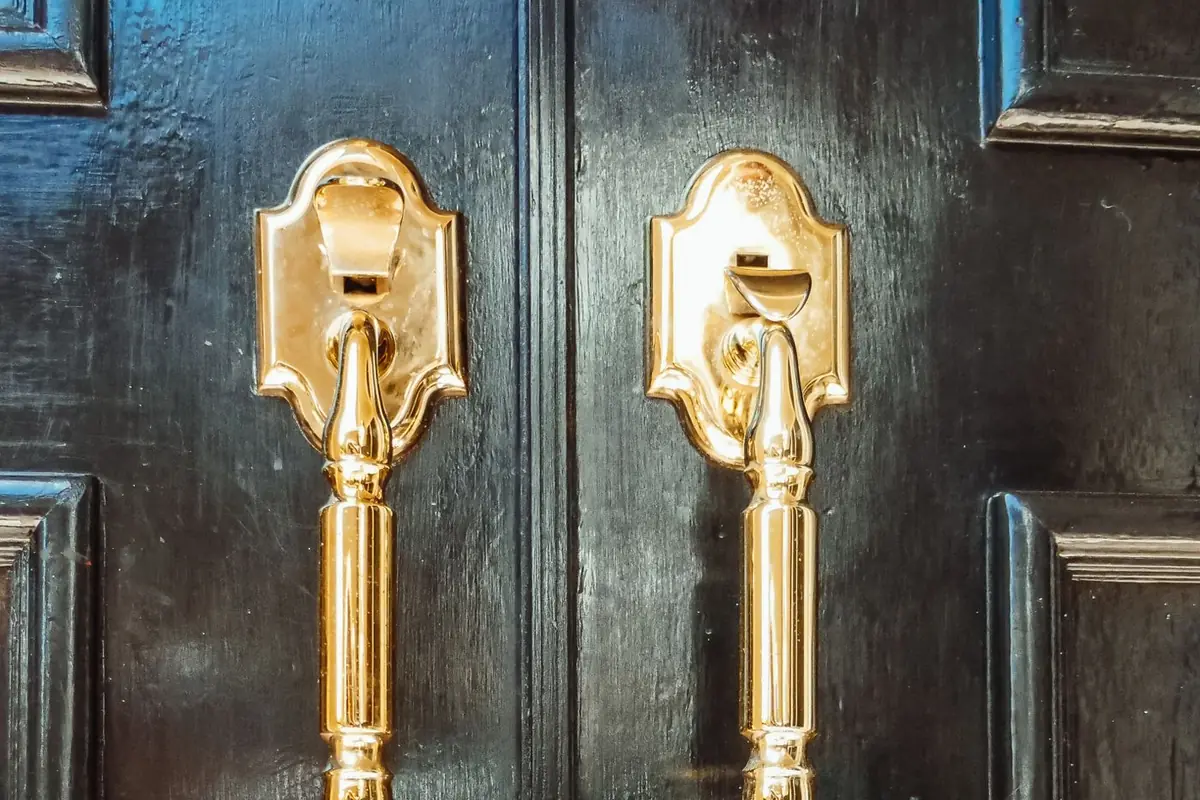 Black front door with brass handles and lockbox