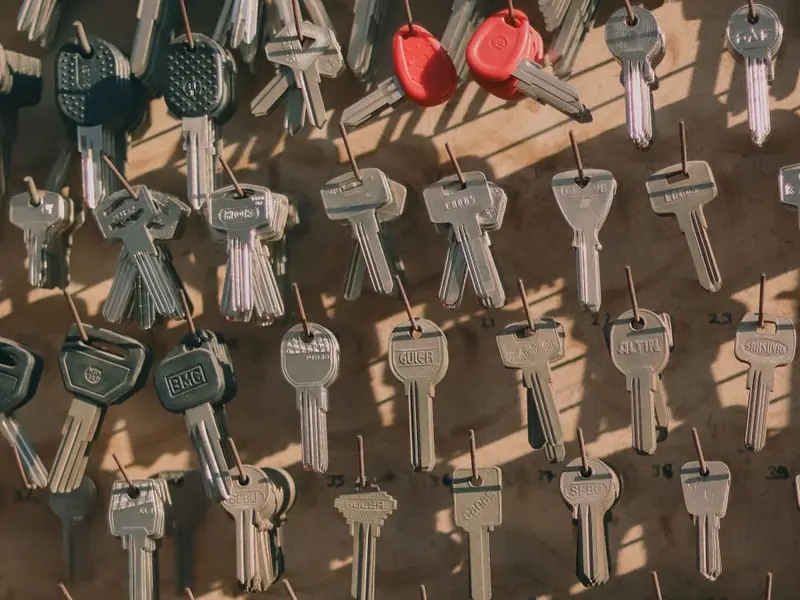 Assorted keys hanging on wall hooks