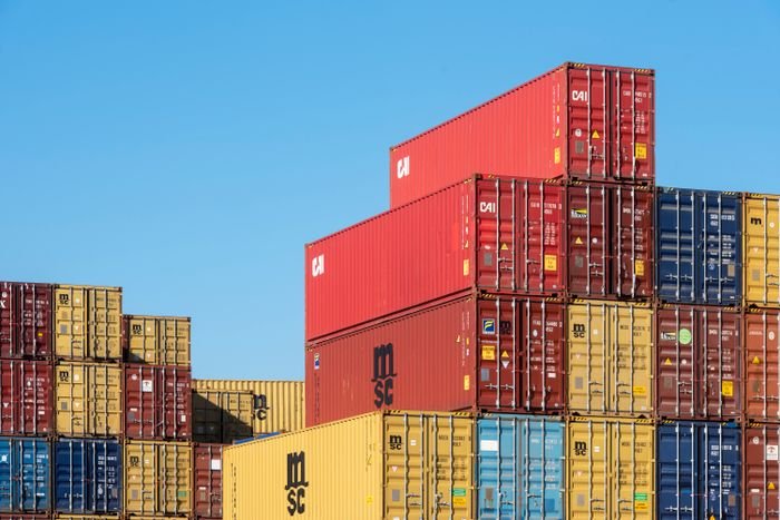 Stacked shipping containers under blue sky