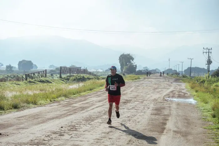 Runner on a dirt road under clear skies