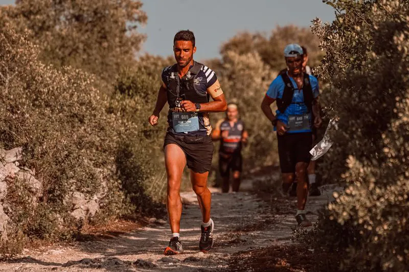 Three runners on a trail section of the course