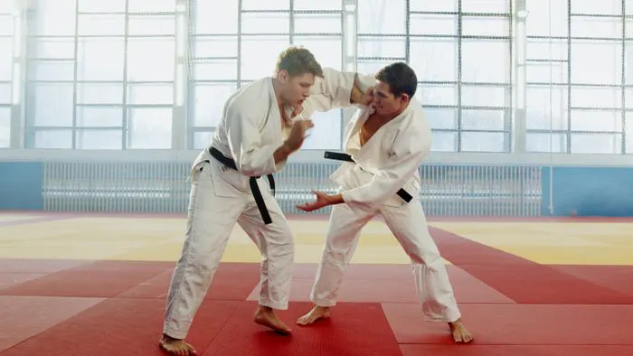 Two adults sparring in karate uniforms