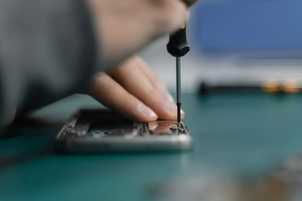 Close-up of a screwdriver opening a smartphone