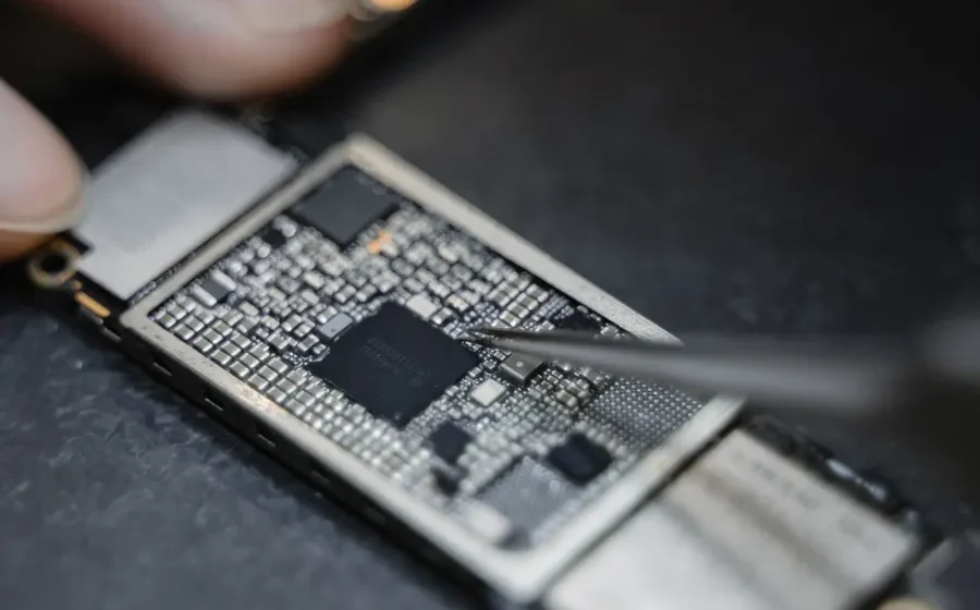 Technician using tweezers on a circuit board