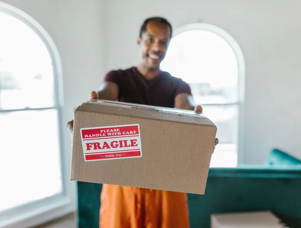 Person holding a box labelled fragile
