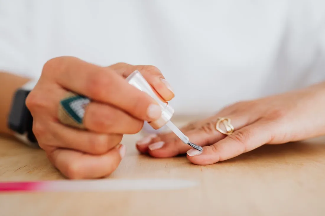 Clear coat being applied to a manicure
