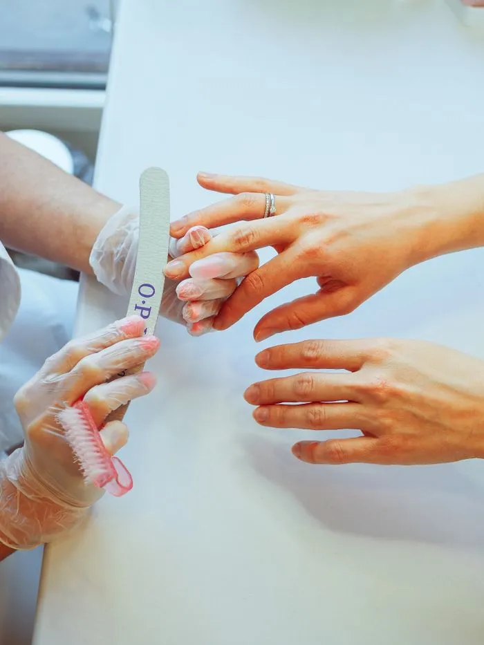 Technician shaping a client's nails