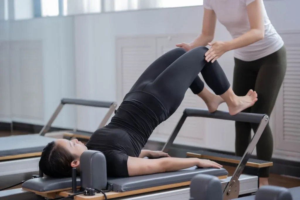 Instructor guiding a client on the reformer