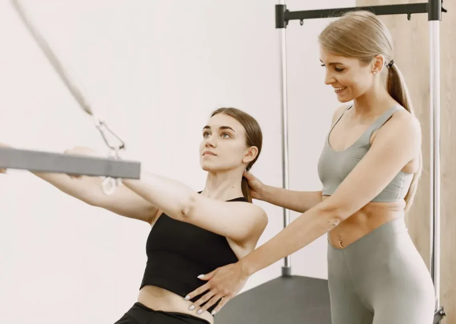 Instructor correcting a client during a Pilates class