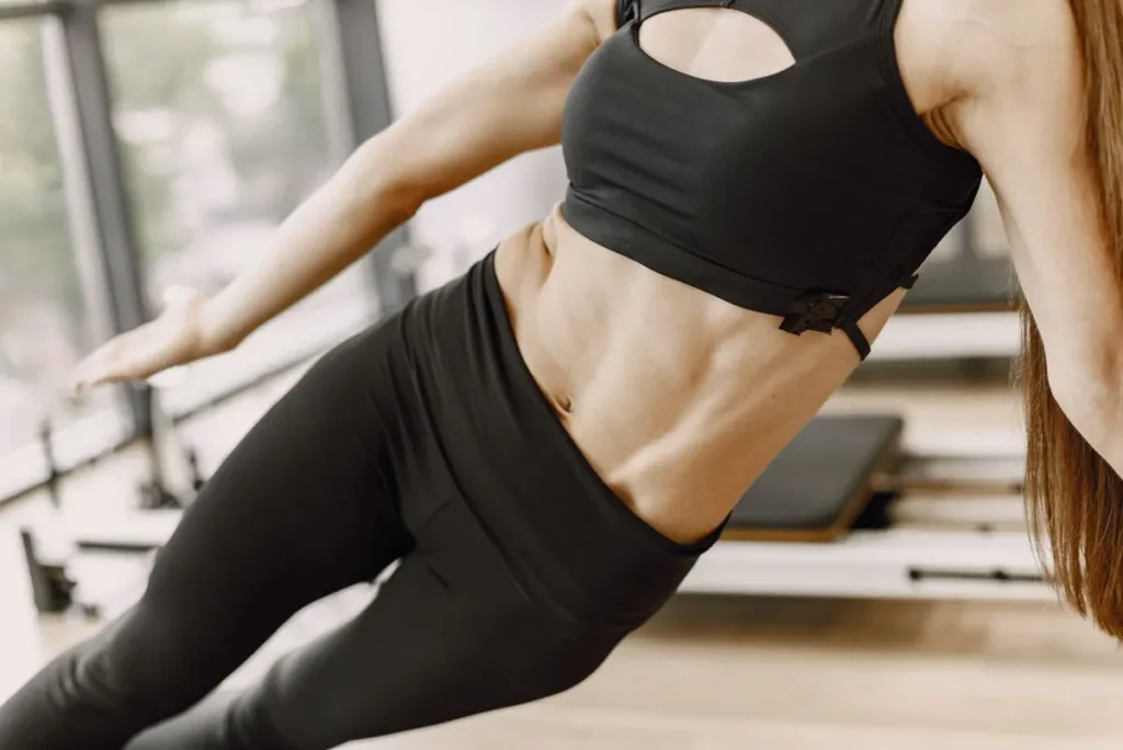 Woman holding a side plank on the reformer
