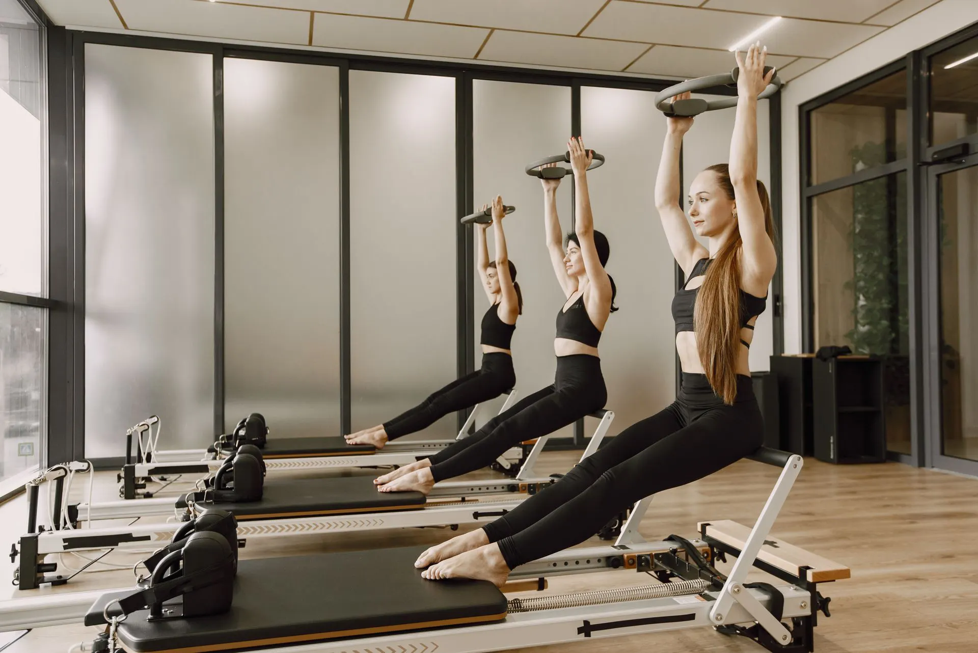 Group reformer Pilates class in a bright studio