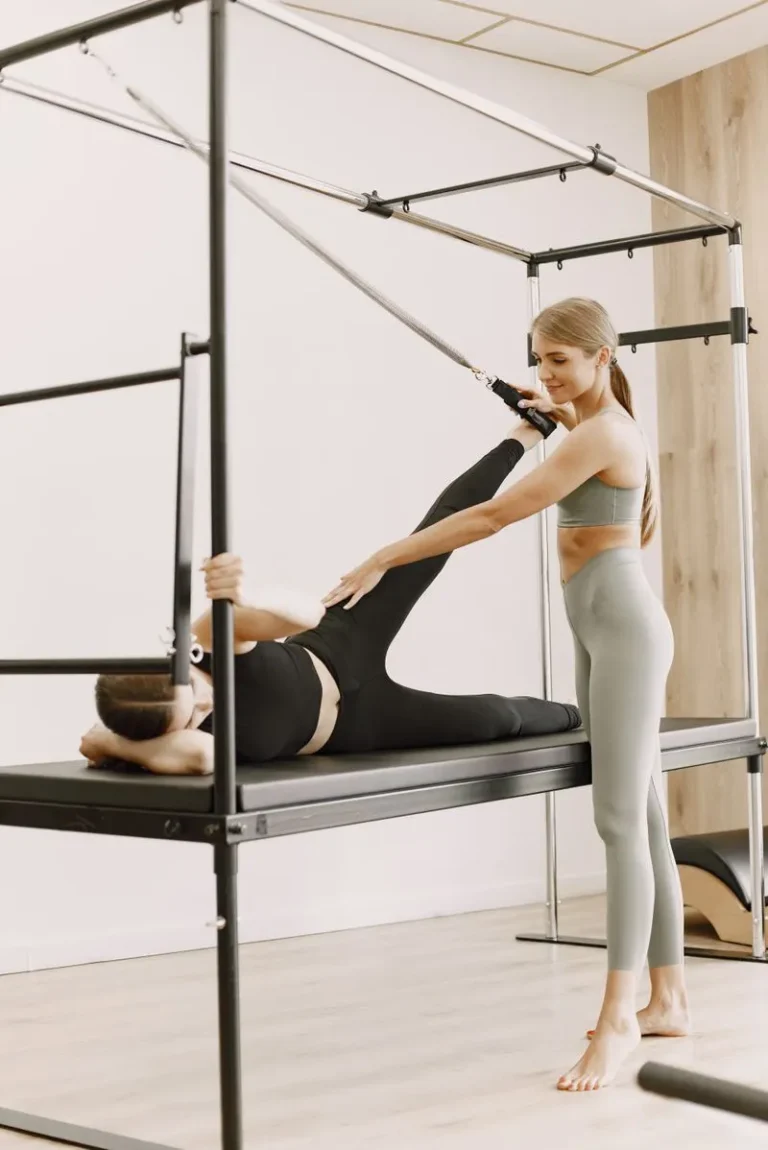 Woman smiling while training on the Pilates tower