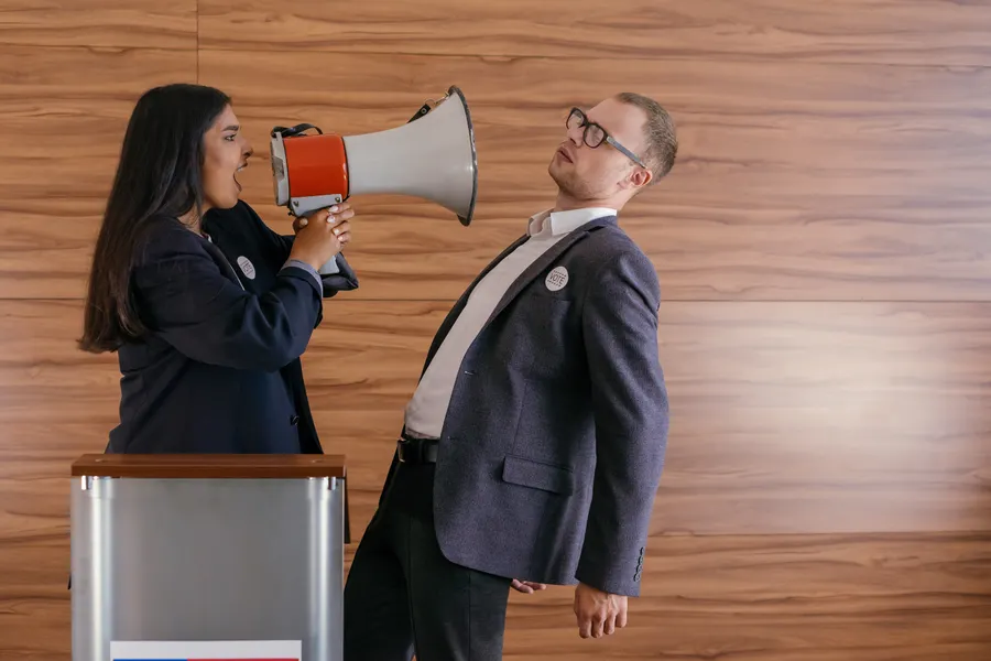 Two people in a heated exchange, one using a megaphone