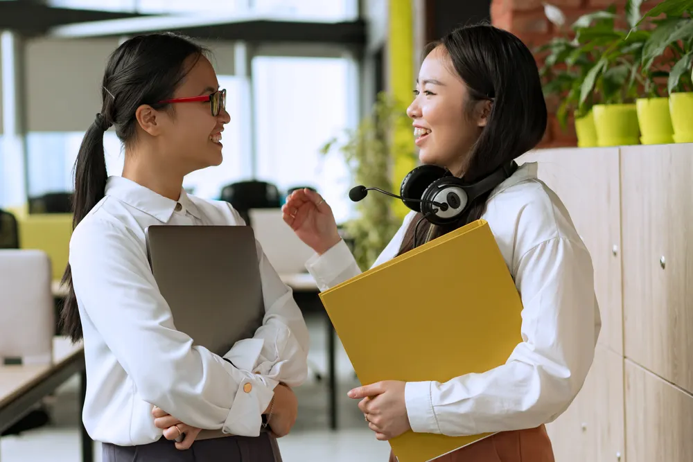 Two communications professionals in conversation in an office
