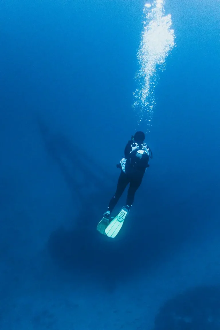 Diver descending above a shipwreck