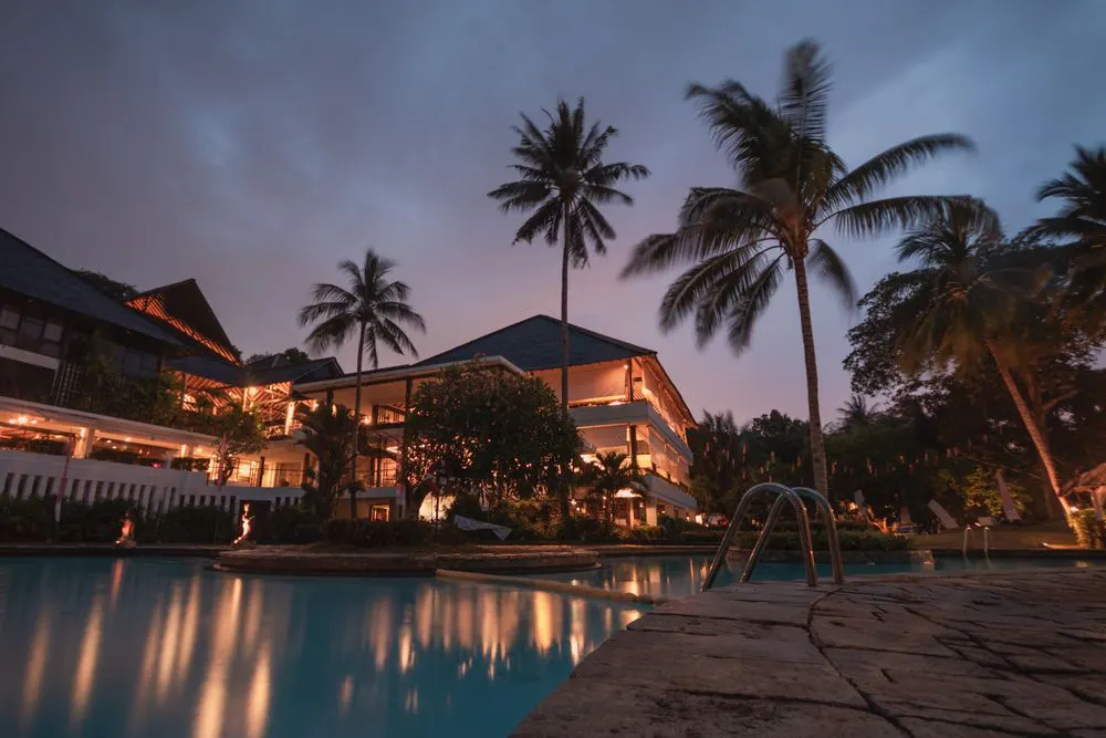 Resort pool lined with palm trees in Coral Bay