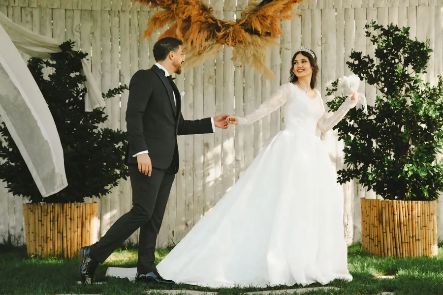 Bride and groom holding hands at an outdoor wedding