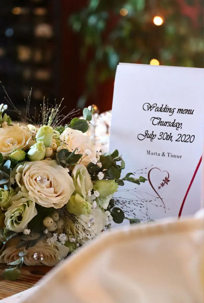 Wedding menu card beside flowers