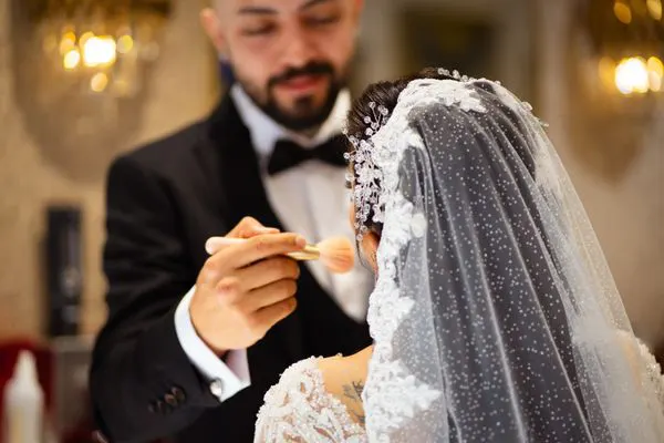 Groom helping the bride with a final touch before the ceremony