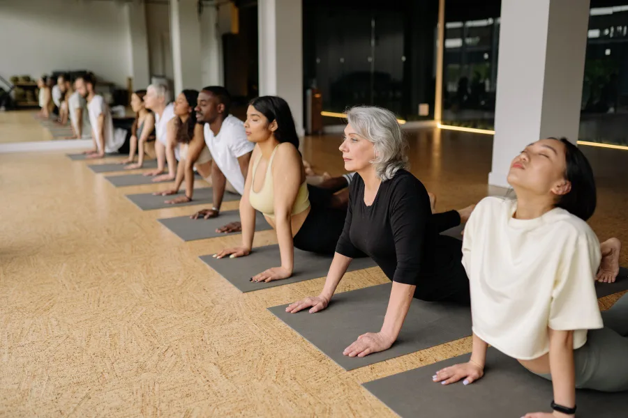 Students practising standing poses in a bright studio