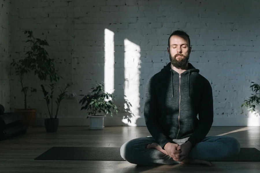 Man seated cross-legged practising breathwork